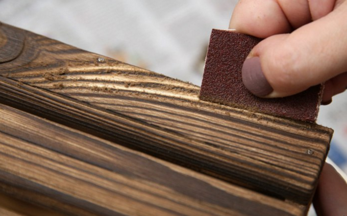 Kartáčovaných drevo s brúsnym papierom. 